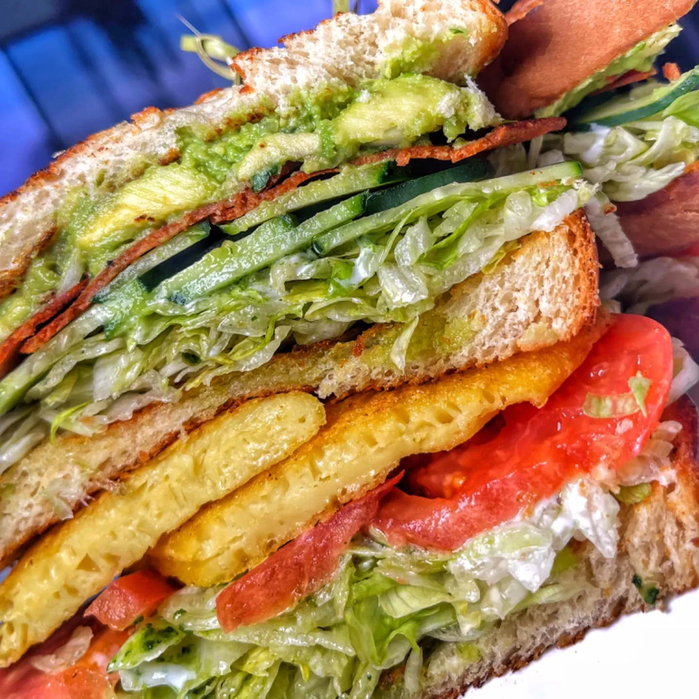 A vegan egg sandwich with lettuce, tomato, and avocado.